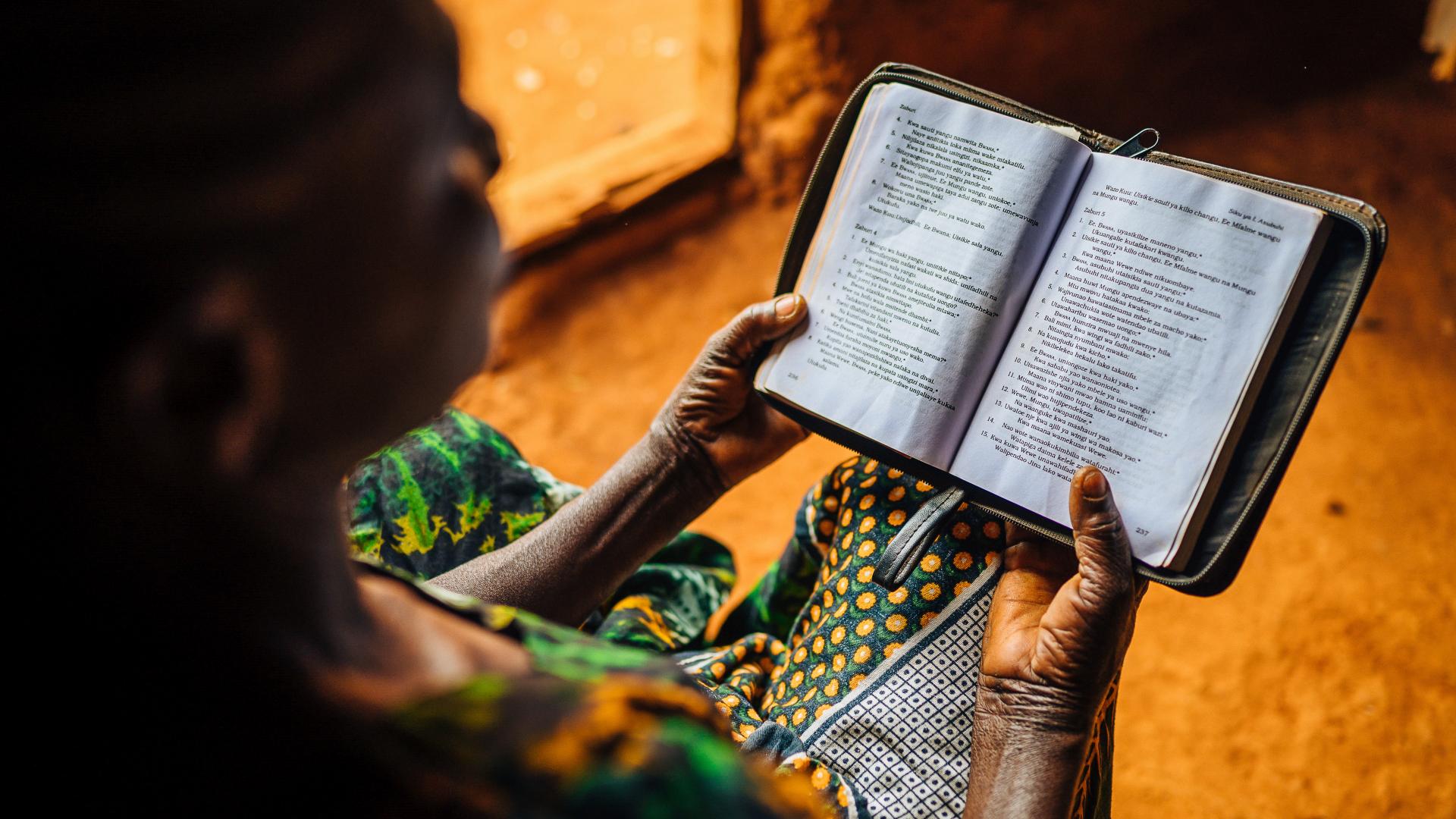 Vrouw leest bijbel in Tanzania