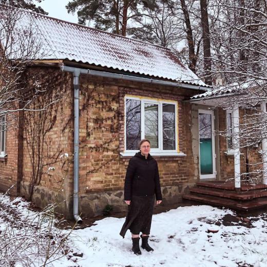 Hanna voor haar herstelde huis in Irpin.
