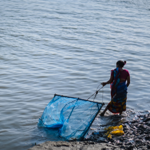 Een vrouw in Bangladesh bij een overstroomde rivier