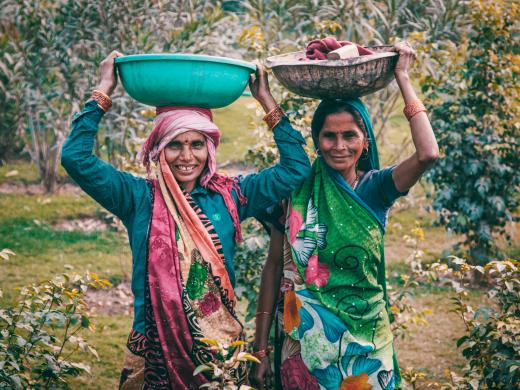 Twee Indiase vrouwen met manden op hun hoofd. Foto: Jose Aragones / Pexels