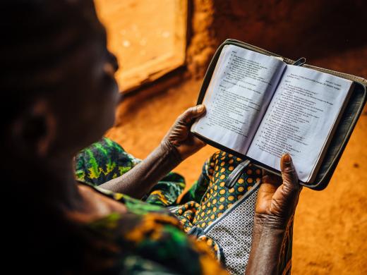 Vrouw leest bijbel in Tanzania