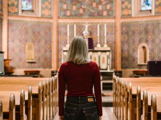 Thelma Schoon die in een kerk staat en naar het altaar en de preekstoel kijkt. 