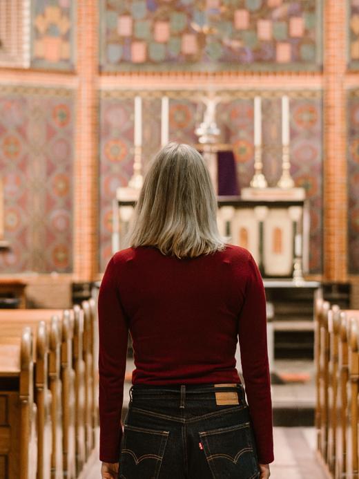 Thelma Schoon die in een kerk staat en naar het altaar en de preekstoel kijkt. 